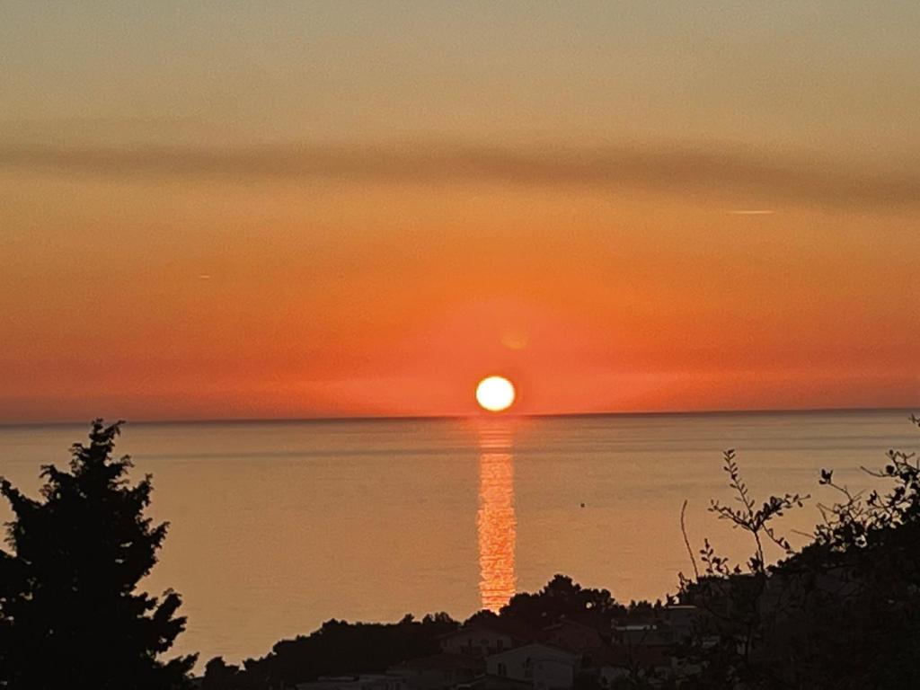 a sunset over the ocean with the sun setting at SeaAdrik in Bar