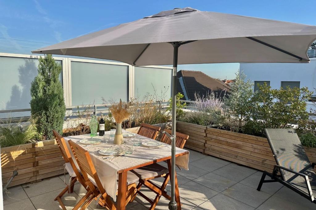 - une table avec un parasol sur la terrasse dans l'établissement Bright apartment with terraces, à Saint-Denis
