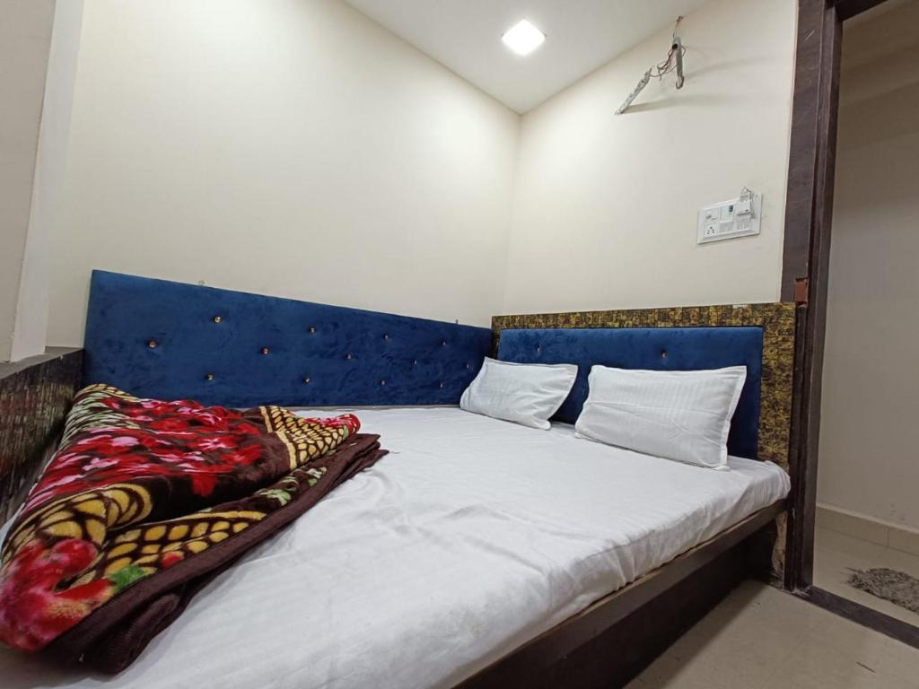 a bed with a blue headboard in a room at BLUE TOWER in Ujjain