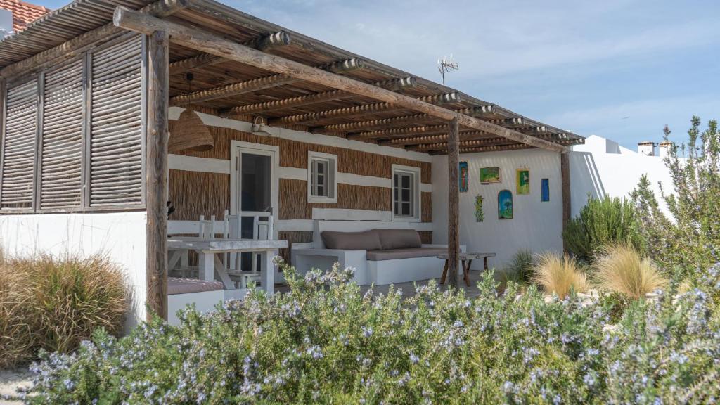 a house with a pergola on the side of it at Cabana da Comporta in Comporta