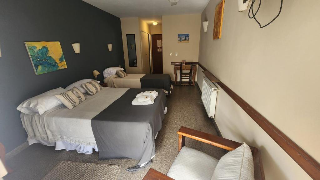 um quarto de hotel com duas camas e um sofá em Hotel Agustin Garcia em Tigre
