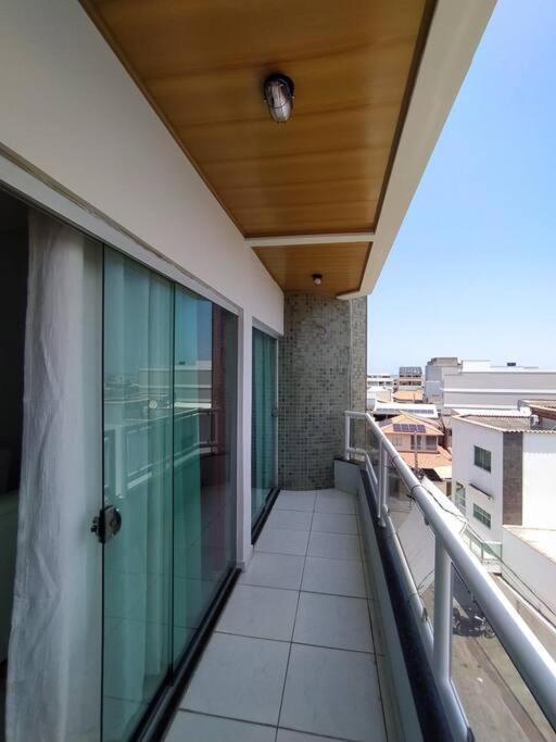 a balcony with a glass door on a building at Apartamento com VISTA MAR , no centro da Ilha de Guriri in São Mateus
