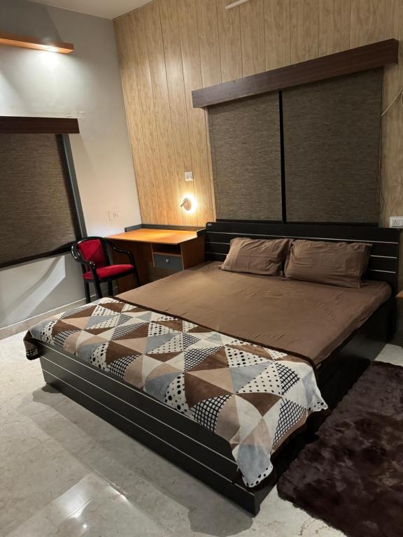 a bedroom with a bed and a desk at Kaashi Flora (2BHK - Ground Floor) in Varanasi