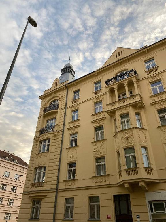 żółty budynek z wieżą zegarową na górze w obiekcie Bohemian Apartments near the Center w Pradze