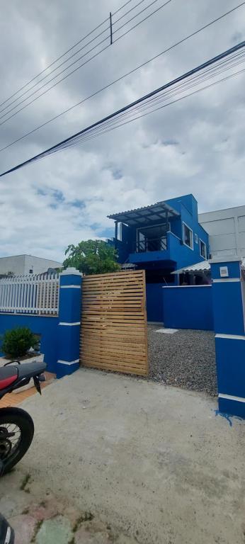 uma casa azul com uma cerca de madeira em frente em Casa Couto em Penha