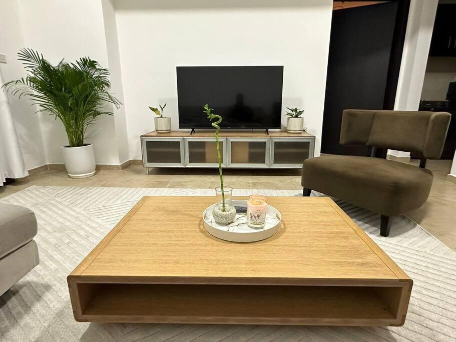 a living room with a coffee table and a tv at Lewish and stylish 1bhk at DSO in Dubai
