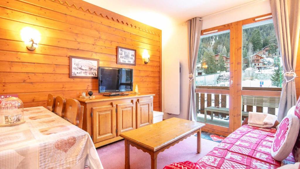 een woonkamer met een tv aan een houten muur bij La Turra 407 - Appt familial 6 pers in Modane