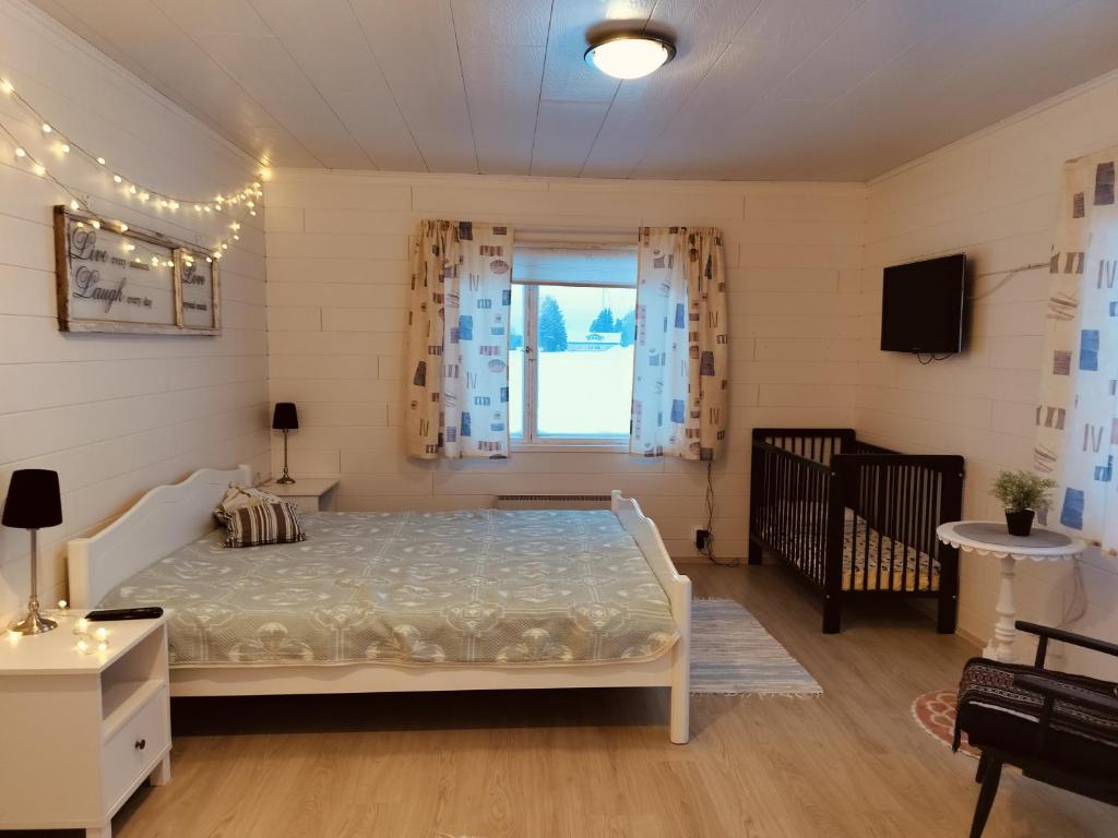 um quarto com uma cama e um berço em Koskela em Kalajoki