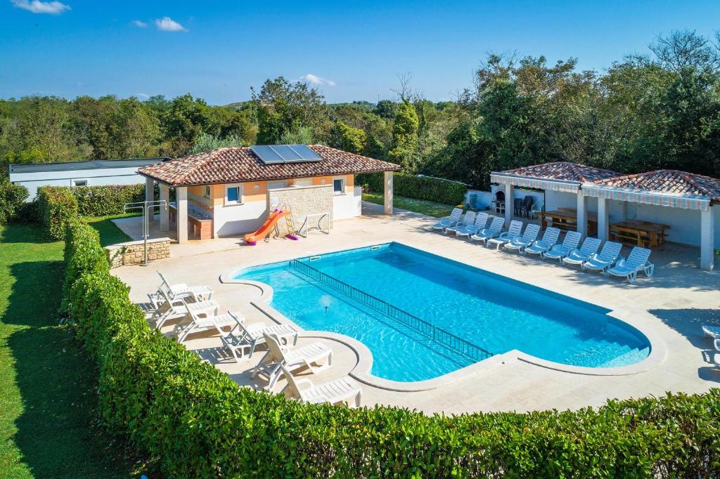 a swimming pool with chairs and a house at Mobile Homes Rocco 2 in Banjole
