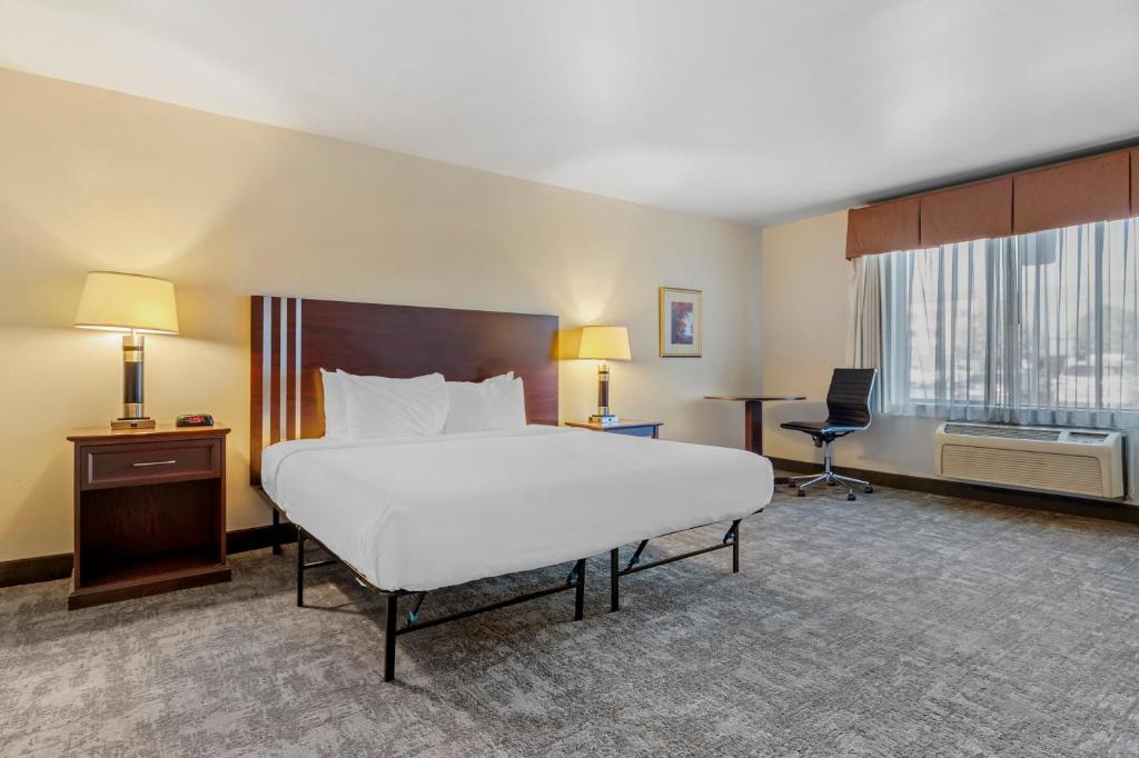 a large hotel room with a large bed and a desk at Seaport Inn & Suites in Lewiston