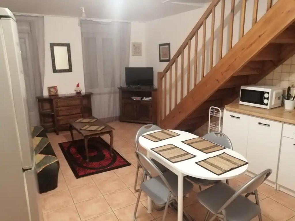 a kitchen with a table with chairs and a microwave at La Molette - 4 personnes in Saint-Julien-Molin-Molette