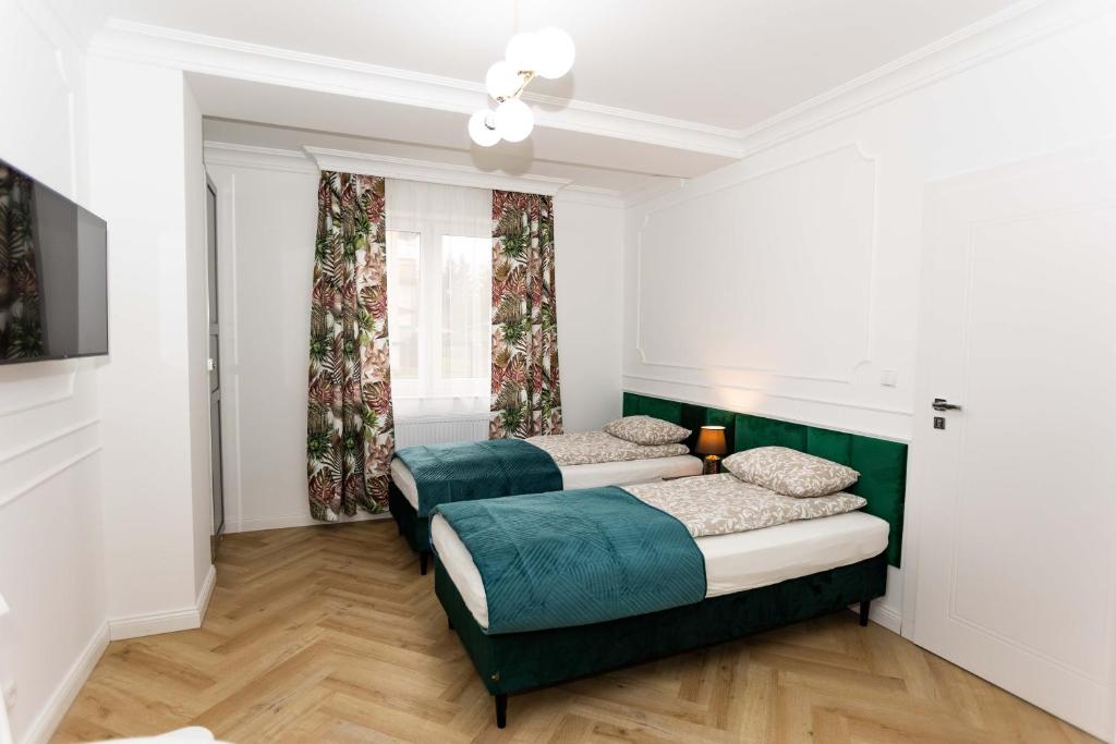 1 dormitorio con 2 camas y sofá en Apartamenty ZZ Stargard, en Stargard