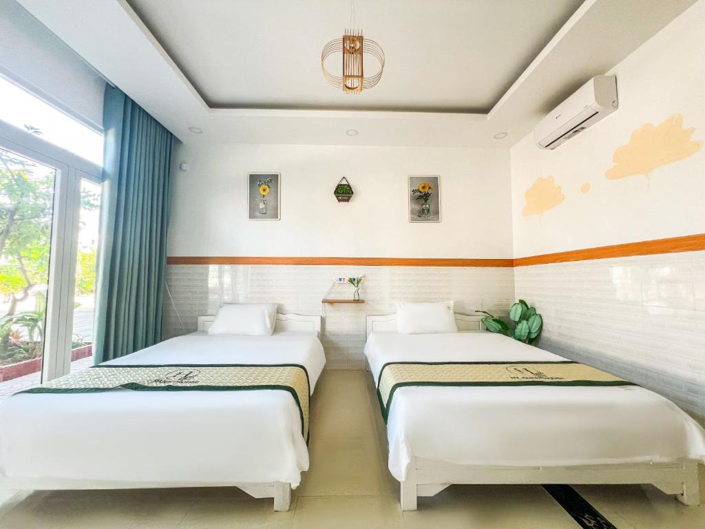 - 2 lits dans une chambre avec fenêtre dans l'établissement HY. GUESTHOUSE PHU QUOC, à Duong Dong