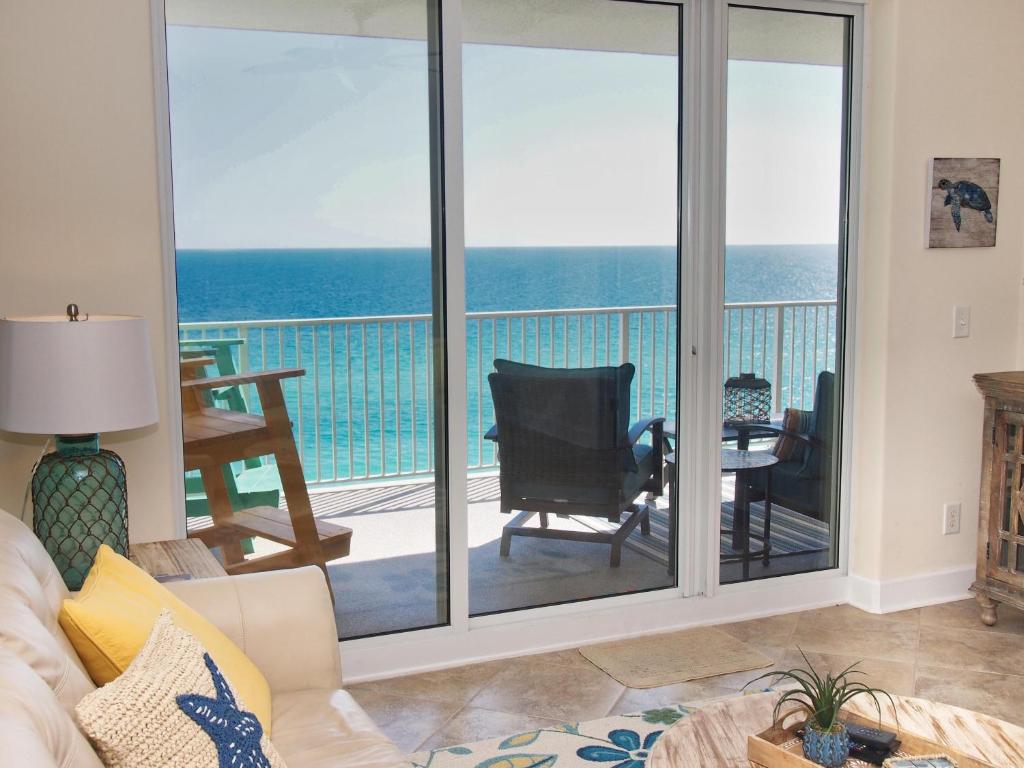 - un salon avec des portes coulissantes en verre offrant une vue sur l'océan dans l'établissement Ocean Reef 1102, à Panama City Beach