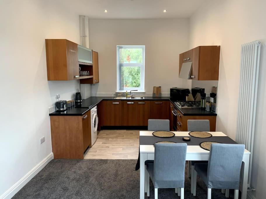 a kitchen with a table and chairs in a kitchen at New large 2 bedroom apartment with private parking 