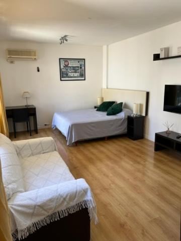 a living room with a bed and a couch at APARTAMENTO LA RURAL in Buenos Aires