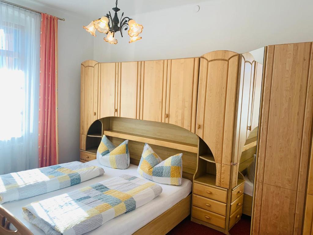 sypialnia z 2 łóżkami i dużym drewnianym zagłówkiem w obiekcie Ferienwohnung Sonnwendhof "Kellerjochblick" w mieście Schwaz