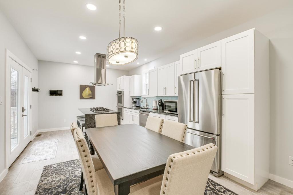 a kitchen with a table and chairs and a refrigerator at Bright and Modern Home 2 Mi to Presque Isle Airport in Presque Isle