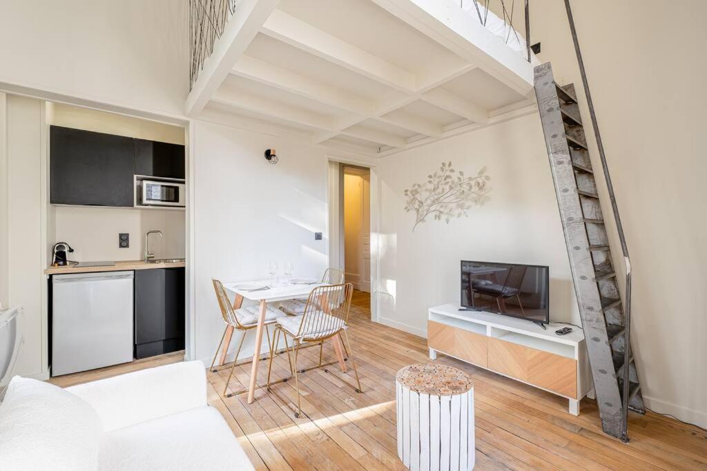 a living room with a table and a kitchen at Le Natural Fauriel avec terrasse in Saint-Étienne