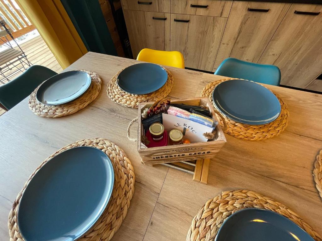 a wooden table with plates and baskets on it at Le Roc in Saint-Jean-d'Aulps