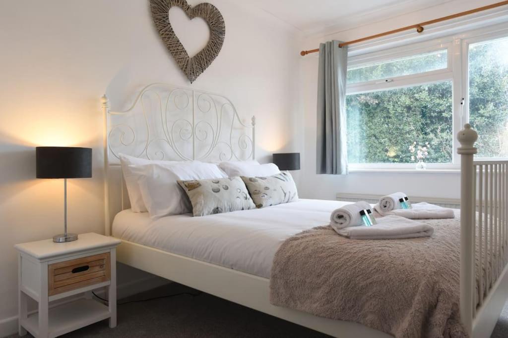 a bedroom with a white bed with two stuffed animals on it at Spacious Family Home Sleeps 6 in Alverstoke