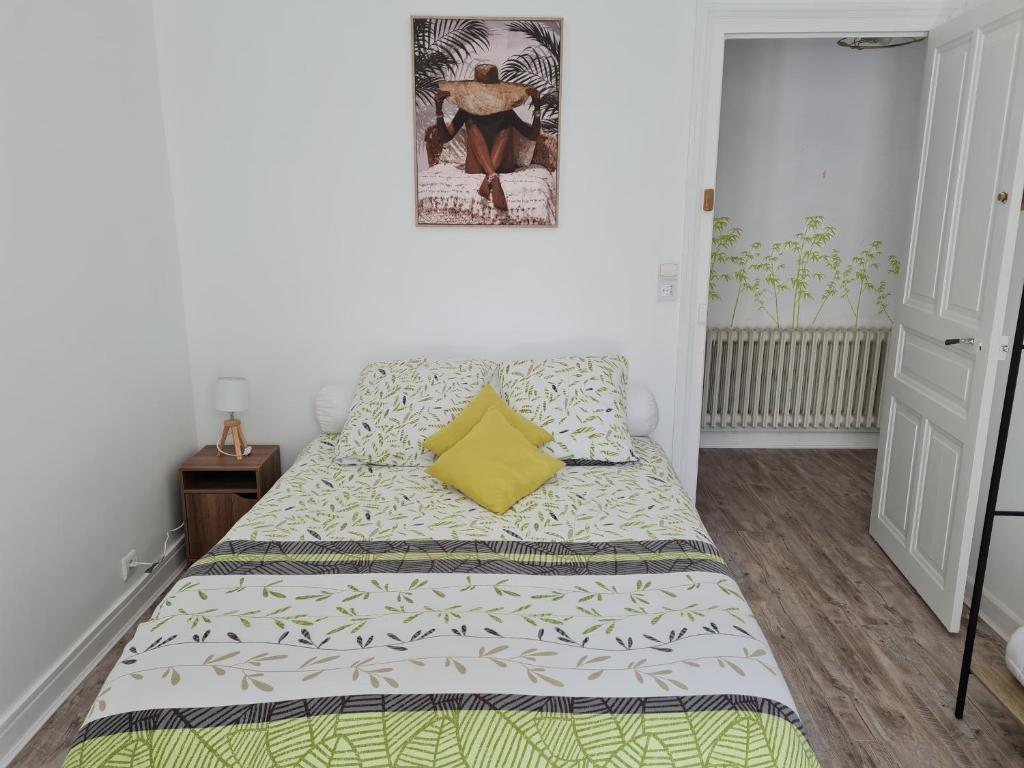 a small bedroom with a bed with a yellow pillow at Le St Jean Bis in Saint-Jean-de-la-Porte