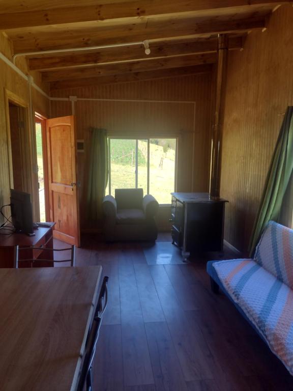 a living room with a couch and a tv in a room at Cabaña bellavista in Cochamó