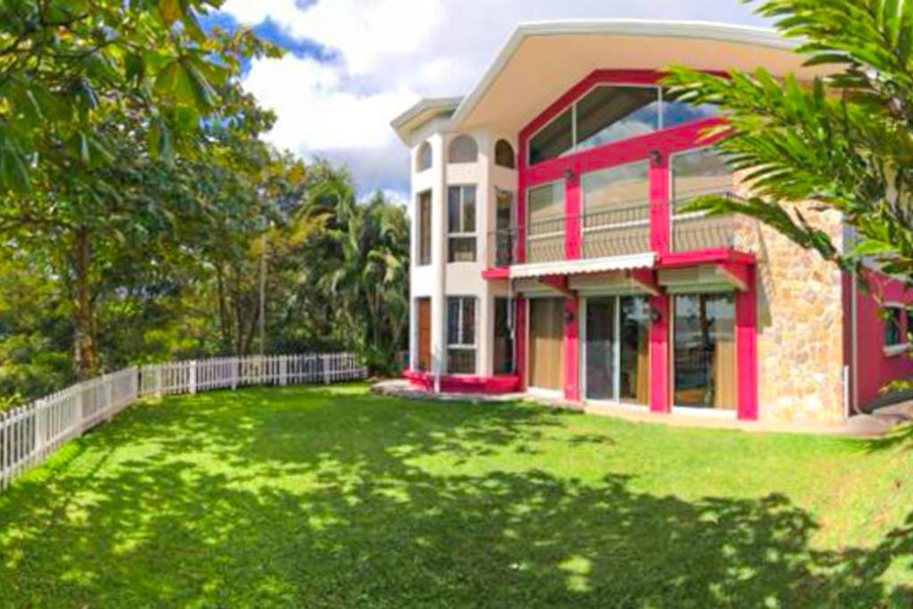 una casa con un patio verde delante de ella en Arenal Lake House, en Nuevo Arenal