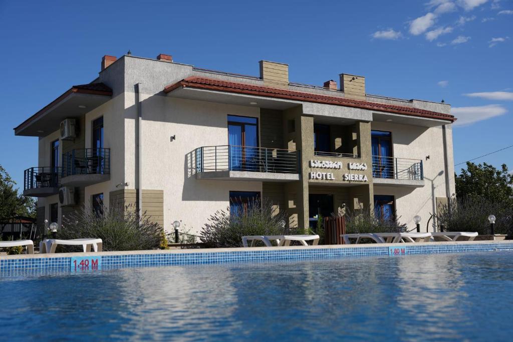 a house with a swimming pool in front of a building at Sierra Hotel Tbilisi in Tbilisi City