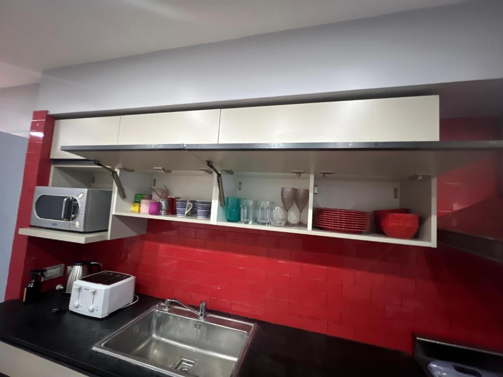 a kitchen with a sink and a microwave at Habitaciones Garay 3100 in Mar del Plata