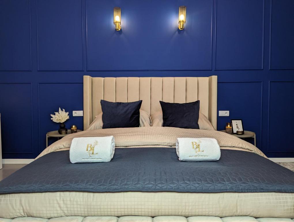 una camera blu con un grande letto con due cuscini di Bella Luna Luxury Suites - Chic Residence in Historic Square a Varsavia