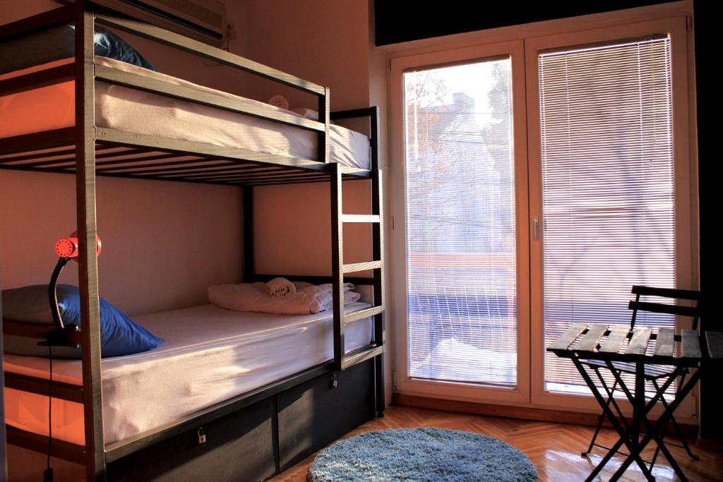 a bedroom with two bunk beds and a window at Blue Orange Hostel in Skopje