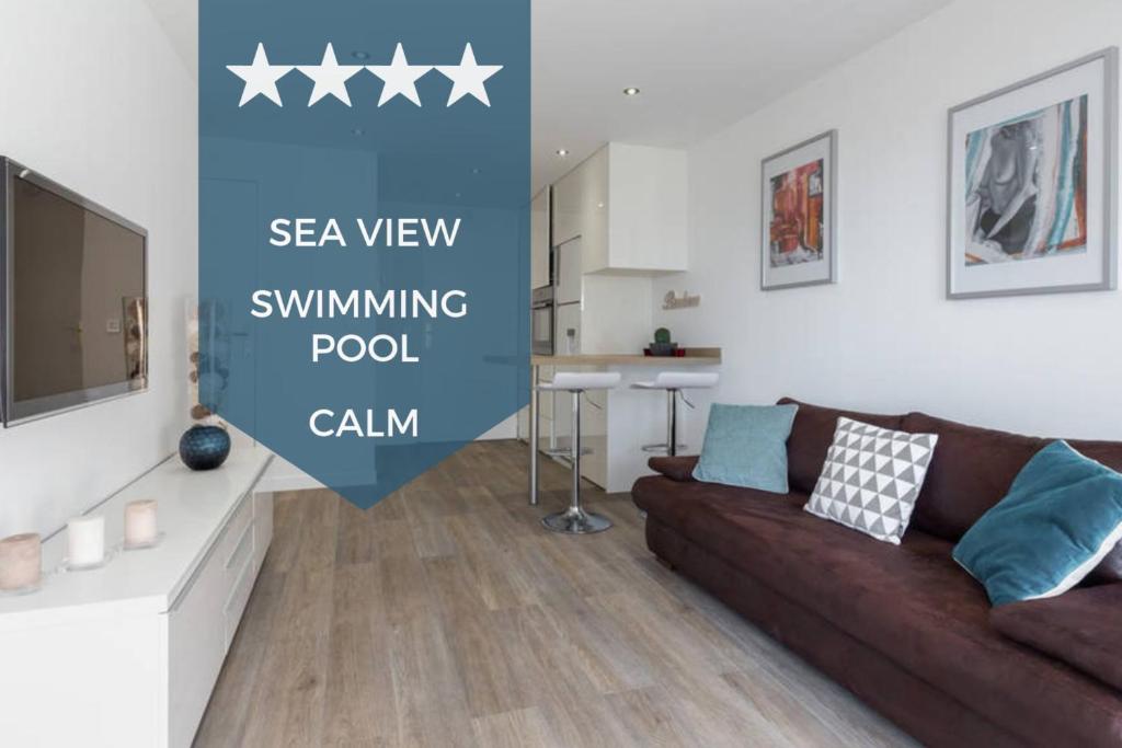 un salon avec un canapé et une télévision dans l'établissement Haven of Peace 1-Br Terrace with Sea View & Pool, à Cannes