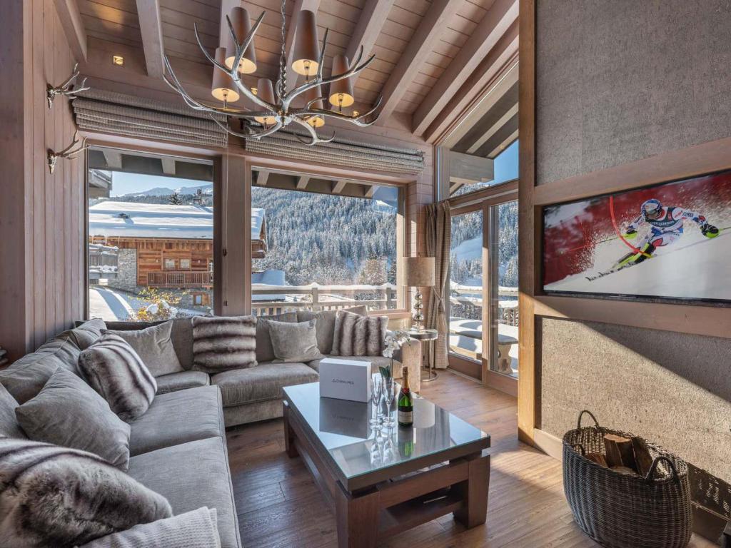 un salon avec un canapé et une télévision dans l'établissement Chalet de luxe avec jacuzzi et garage à Courchevel - FR-1-563-30, à Courchevel