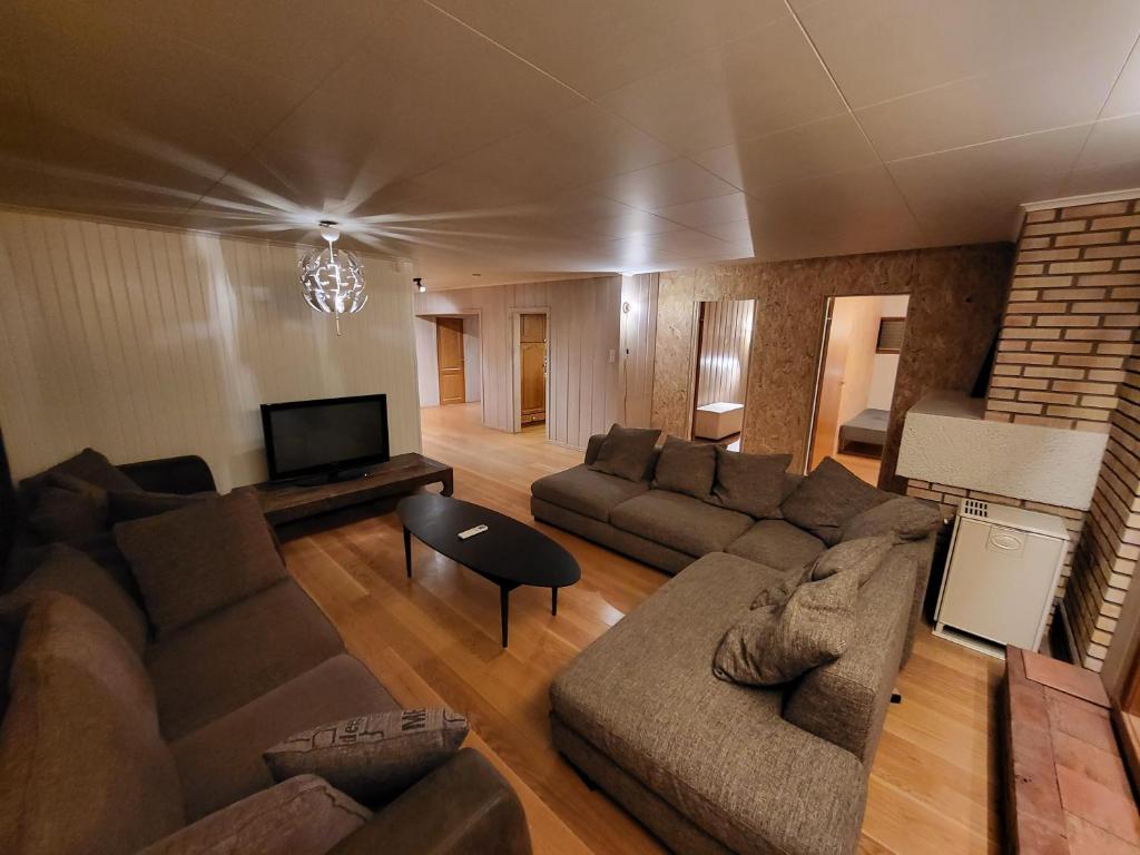 sala de estar con sofá y TV en 6 Bedrooms, 8 Guest Apartment in Kjeller Lillestrøm - 5mins from Lillestrøm Station, 3 mins to OSLOMET, en Lillestrøm