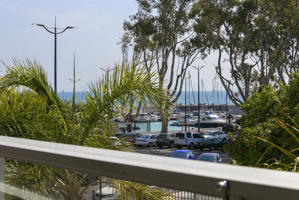 a balcony with a view of a marina with cars parked at Gordonia 10 by HostAgents in Gordonʼs Bay