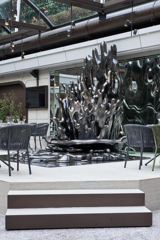 a large metal sculpture in a building with chairs at VP Madroño in Madrid