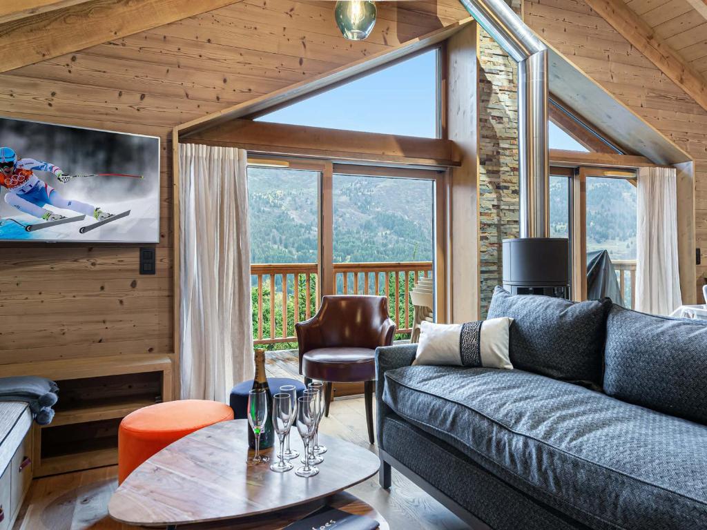 a living room with a couch and a large window at Chalet Méribel, 7 pièces, 12 personnes - FR-1-565-1 in Les Allues