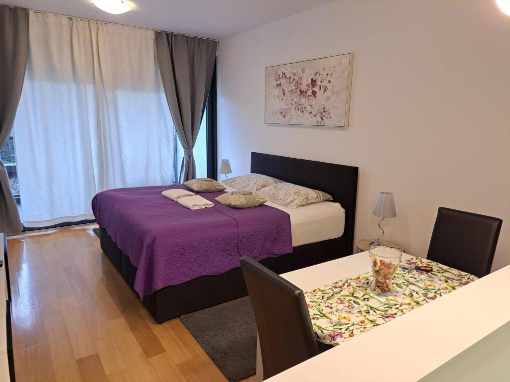 1 dormitorio con 1 cama y 1 mesa con sillas en Nova galerija Ema, en Zagreb