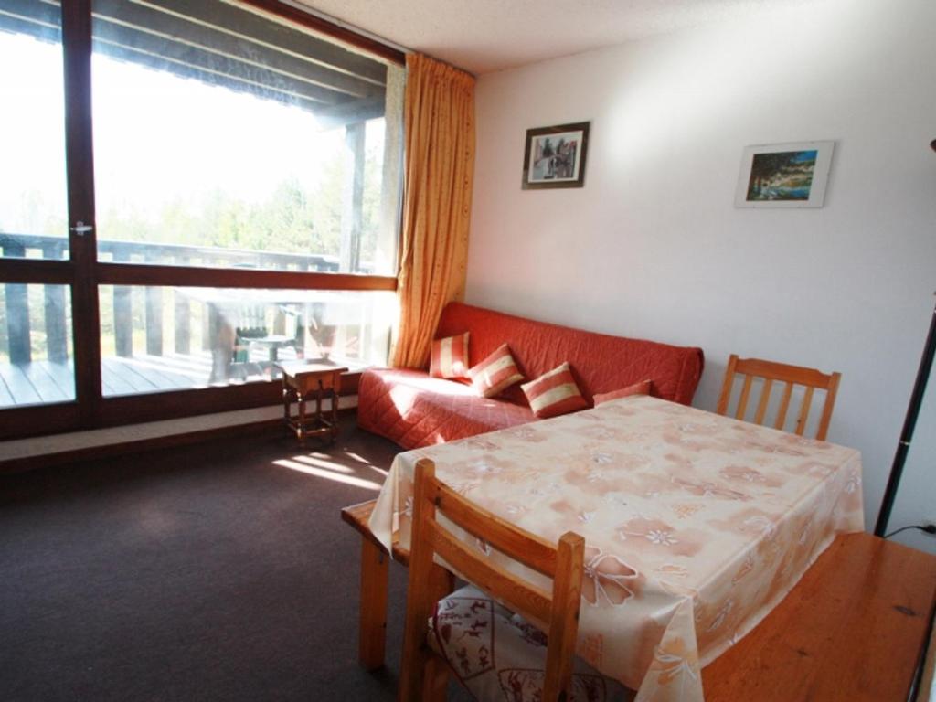 sala de estar con sofá rojo y mesa en Appartement Pra-Loup, 2 pièces, 4 personnes - FR-1-165A-85 en Uvernet