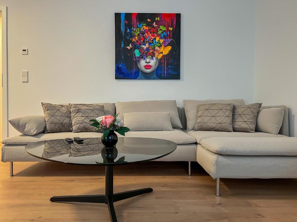 a living room with a couch and a table with a painting at Appartement House Jena in Jena