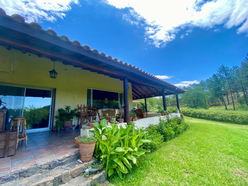 a house with a patio and a yard at Posada Sausalito in Santa Rosa de Calamuchita