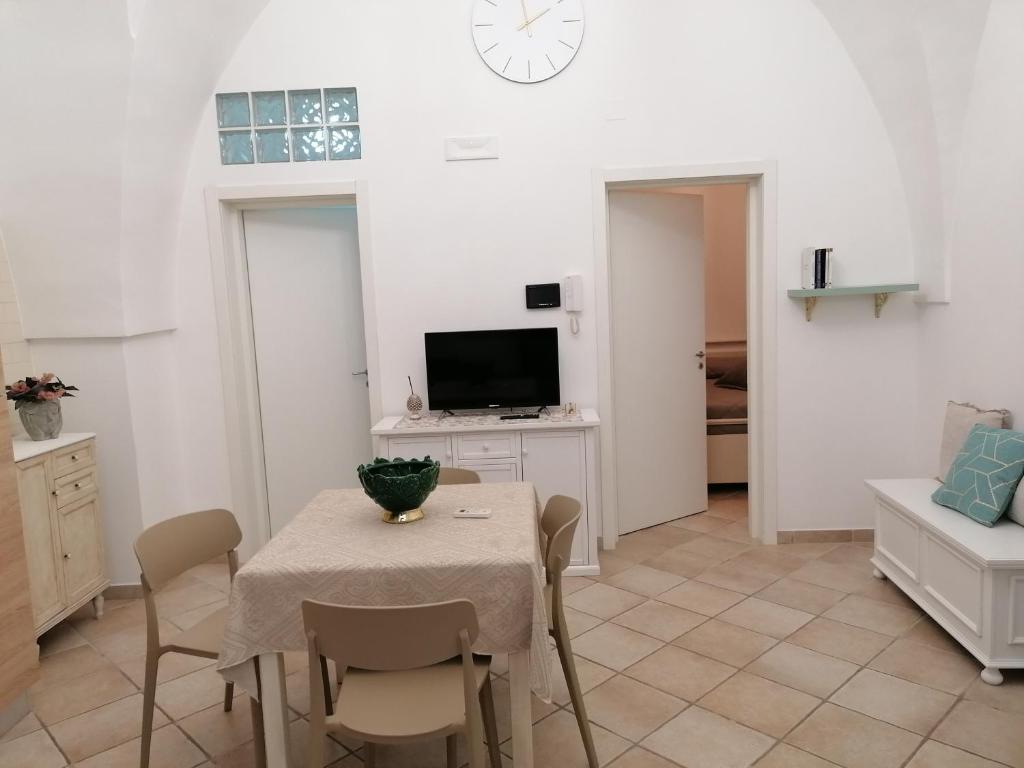 - une salle à manger avec une table, des chaises et une télévision dans l'établissement ELISEA HOUSE MARIO PAGANO, à Oria