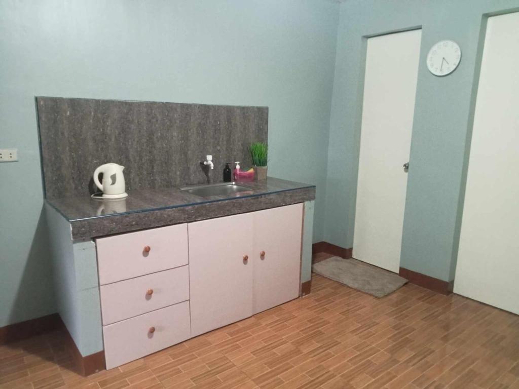 ein Badezimmer mit einem Waschbecken und einer Theke in der Unterkunft Travellers&Backpackers Apartment in Calapan