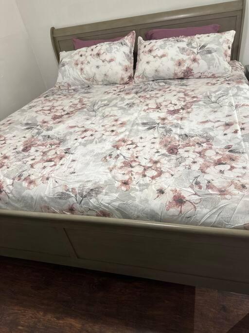 a bed with pink flowers on it in a bedroom at Classis King and Queen suites in Schenectady