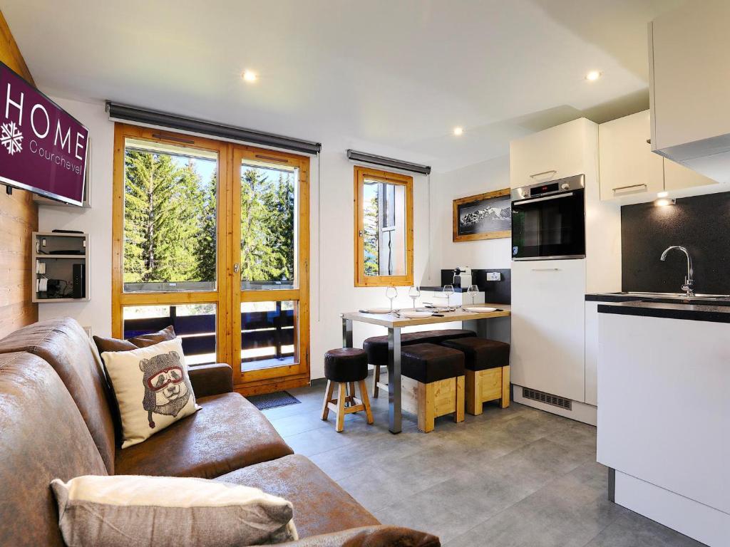 a living room with a couch and a kitchen at Charmant appartement rénové avec accès direct aux pistes - FR-1-575-114 in Courchevel
