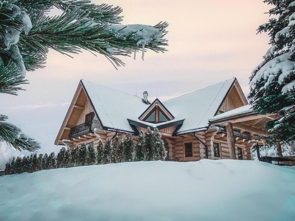 ein Holzhaus im Schnee in der Unterkunft Zrubová chata Panorama Family in Habovka