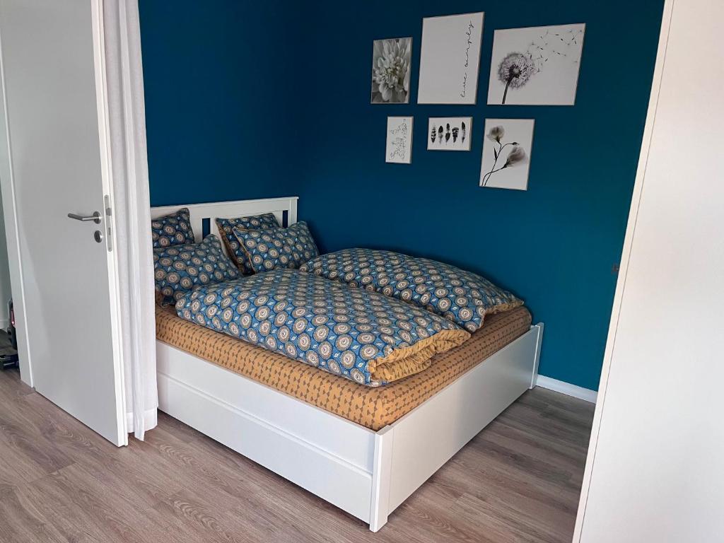 ein Schlafzimmer mit einem Bett mit einer blauen Wand in der Unterkunft FEWO "Rabennest " Gemütliche Wohnung nahe Rabensteinklinikum - kein separates Schlafzimmer, Studiowohnung in Chemnitz