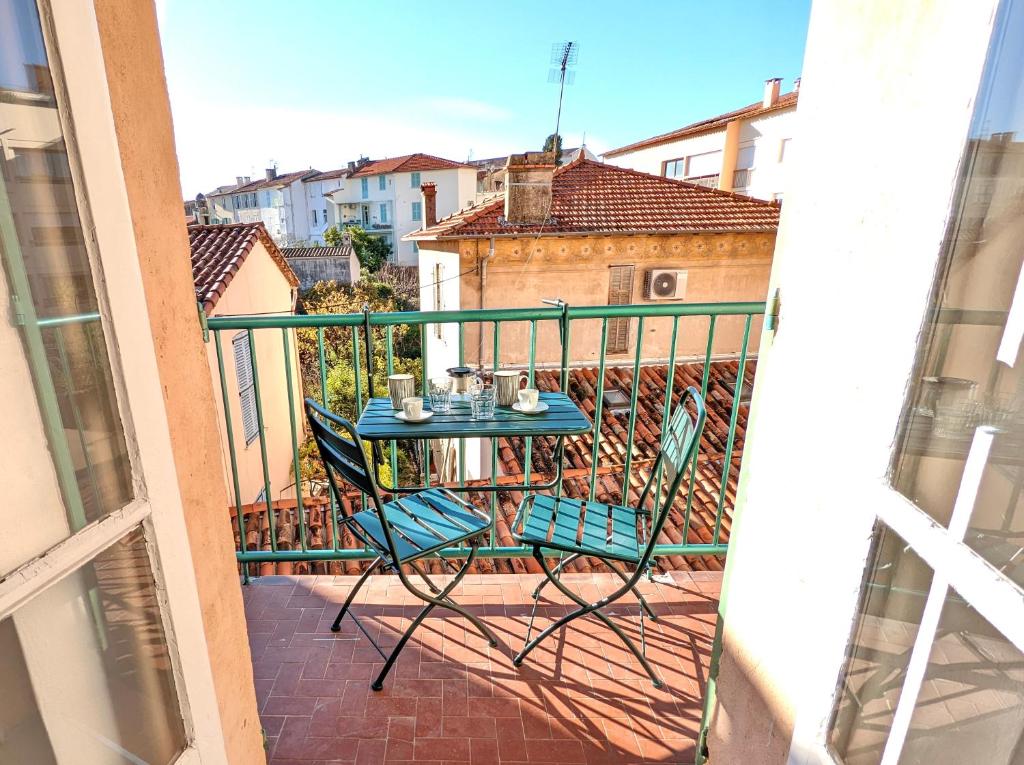 - une table et des chaises sur le balcon d'un appartement dans l'établissement La maison du douanier. Un balcon au soleil, à Antibes