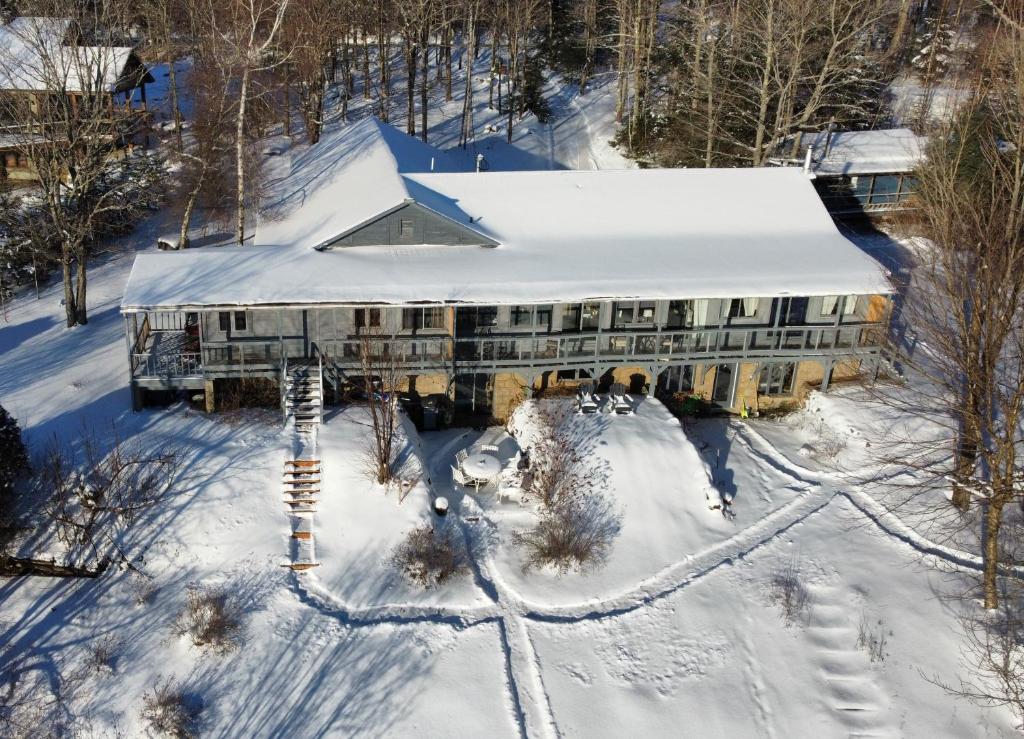 - une vue aérienne sur l'auberge dans la neige dans l'établissement Le Lodge du lac, à Saint-Faustin–Lac-Carré